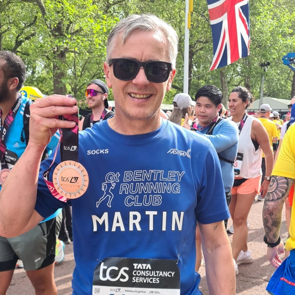 Martin holding his finishers medal.